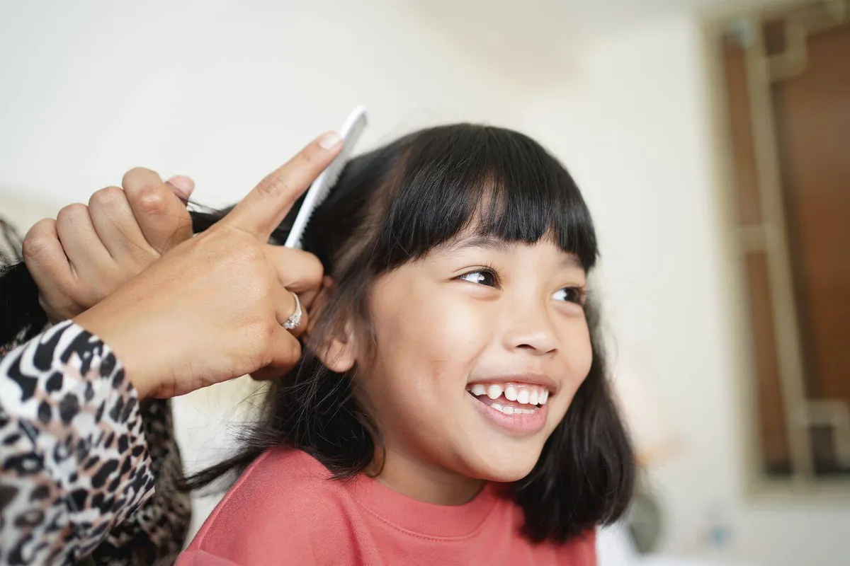 Smiling girl during a professional lice removal treatment